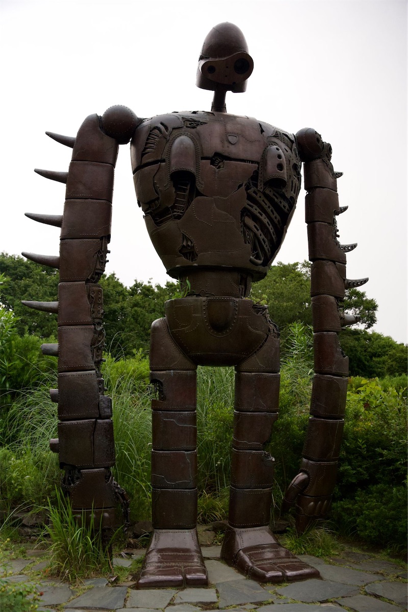 Grand robot en bronze du film « Le Château dans le ciel », debout dans la verdure