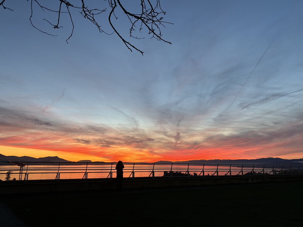 Coucher de soleil orange et rose sur un lac et des montagnes